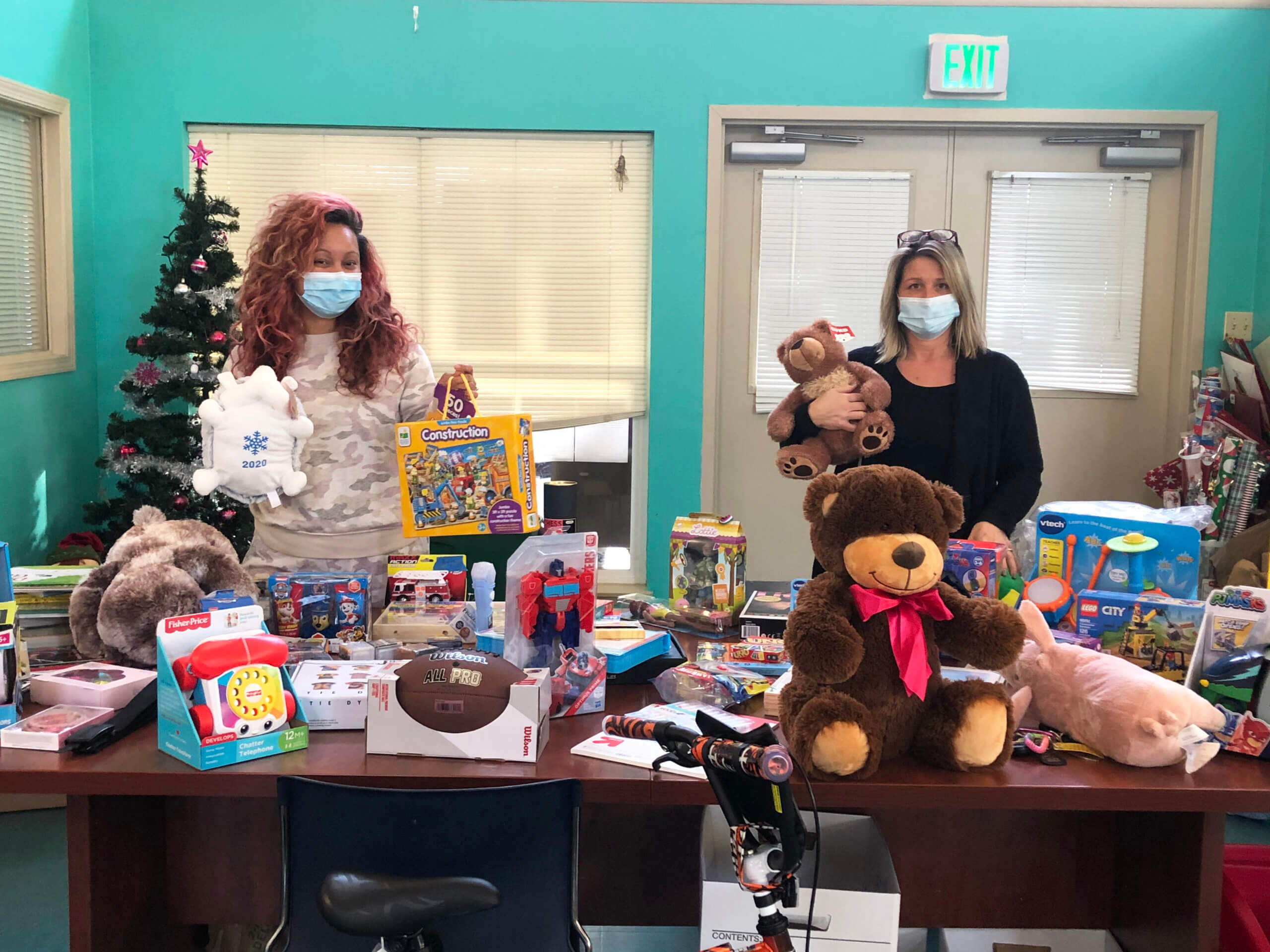 Two women with surrounded by toys for the adopt a child program