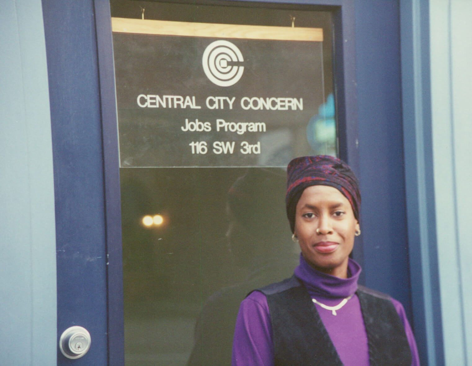 Woman standing in front of CCC job program sign in the 90s