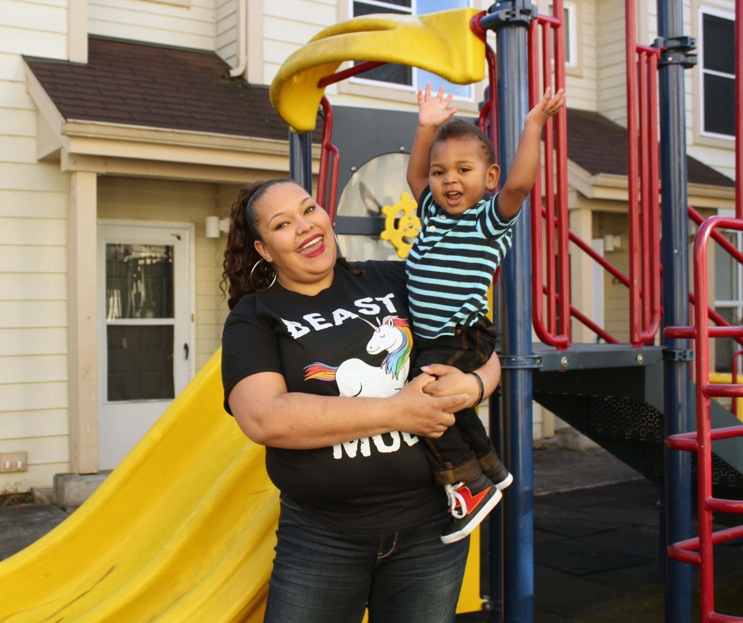 Client Celeste holding a child in front of playgroud