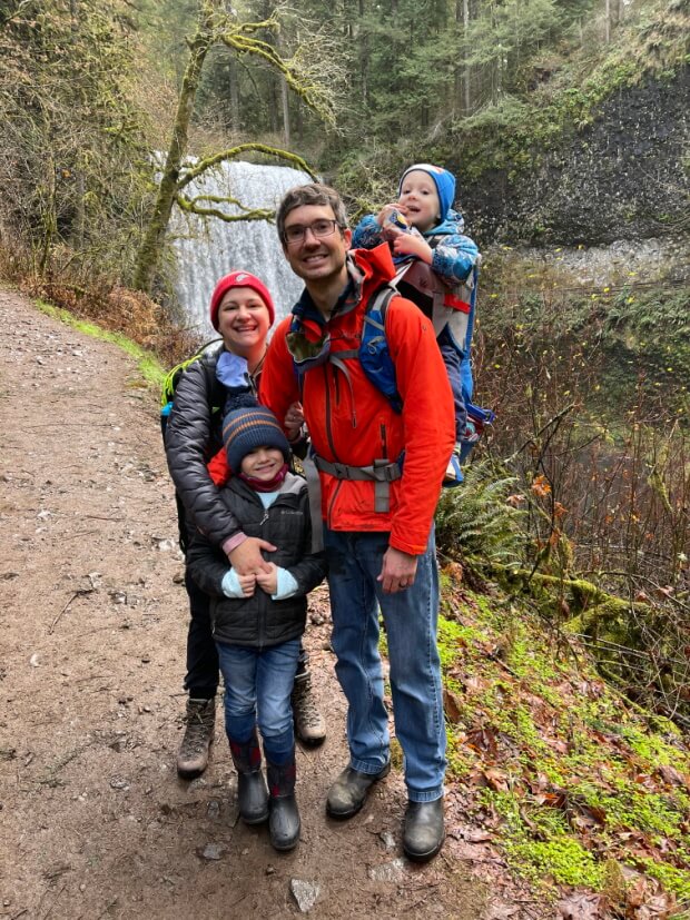 A family smiles while hiking
