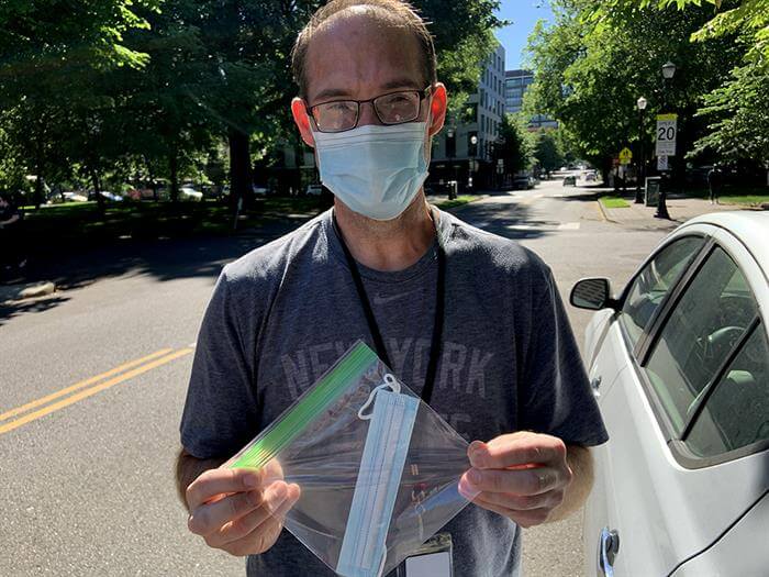 Man holding ziplock bag with sterile mask inside the bag
