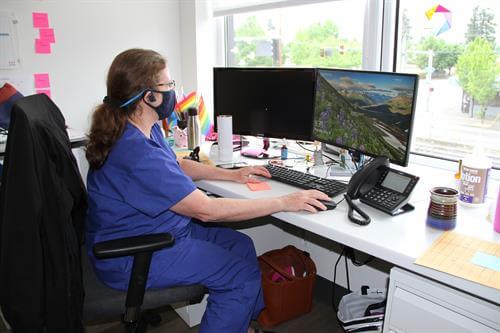 Nurse sitting at desk looking at computer screen