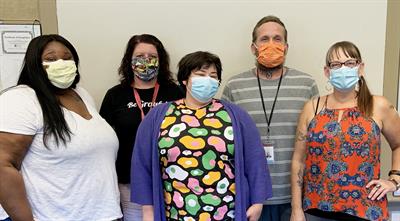 Group of people wearing face mask posing for photo