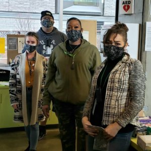 Four Transition Projects staff pose wearing their new ShedRain masks, donated by CCC and ShedRain.